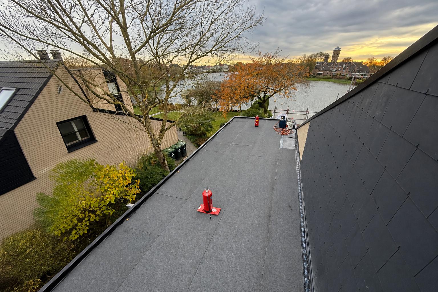Plat dak met bitumen dakbedekking in aanbouw; dakdekkerswerk en veiligheid op locatie door Nouwen Bouw & Dakservice