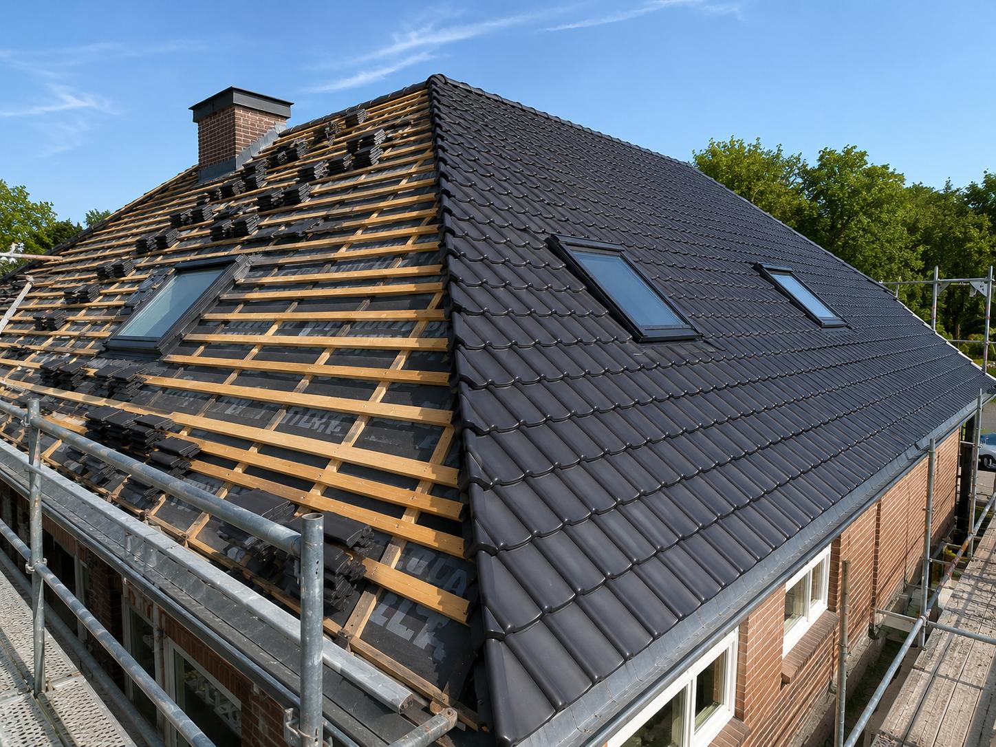 Hellend pannendak deels gedekt met donkere dakpannen en dakkapellen; andere dakvlakken met latten en stapels pannen klaar voor leggen, steiger langs de bakstenen woning.